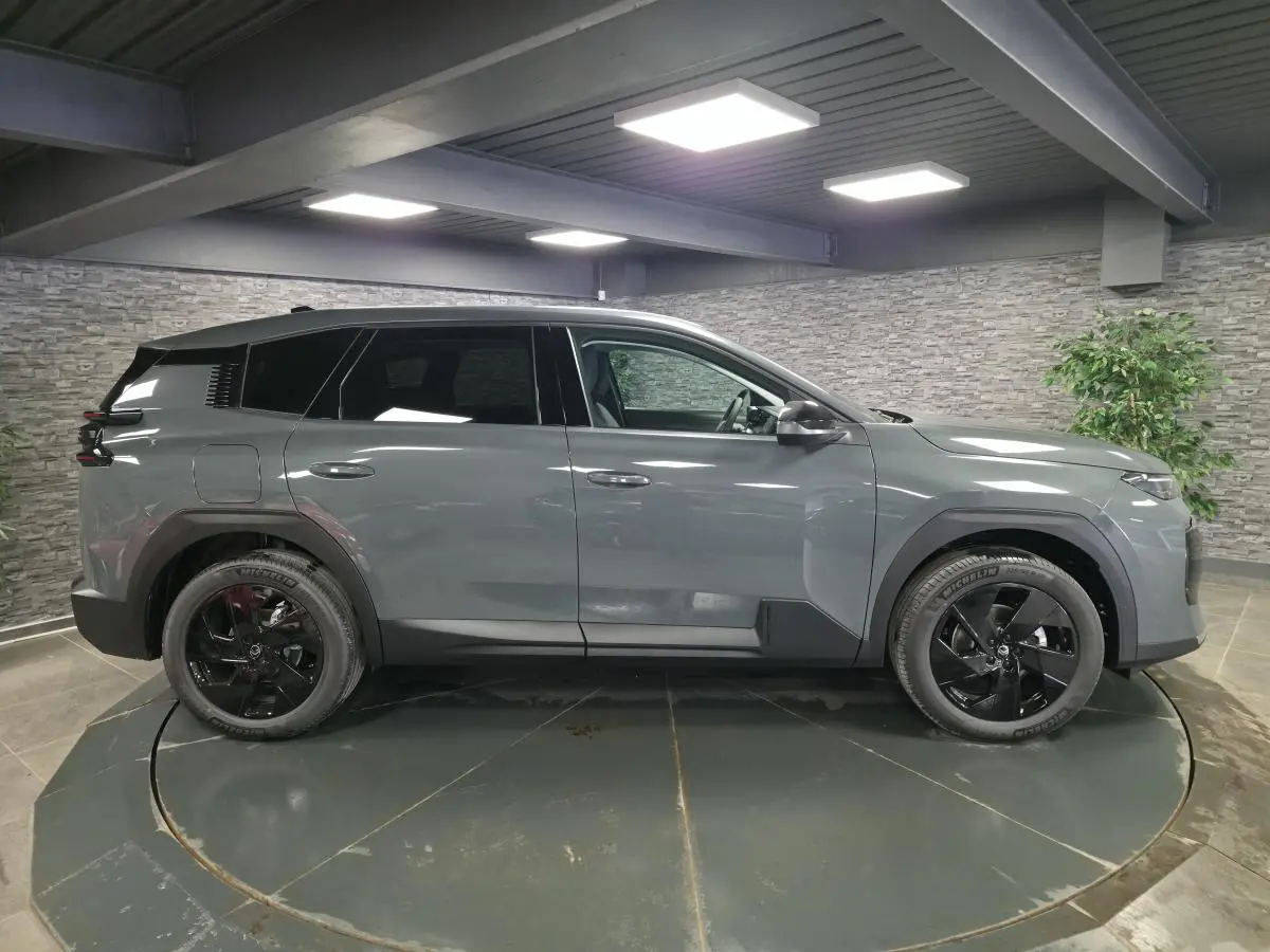 Vue de profil côté gauche d'un Citroën C5 Aircross gris métallisé avec jantes noires en intérieur.