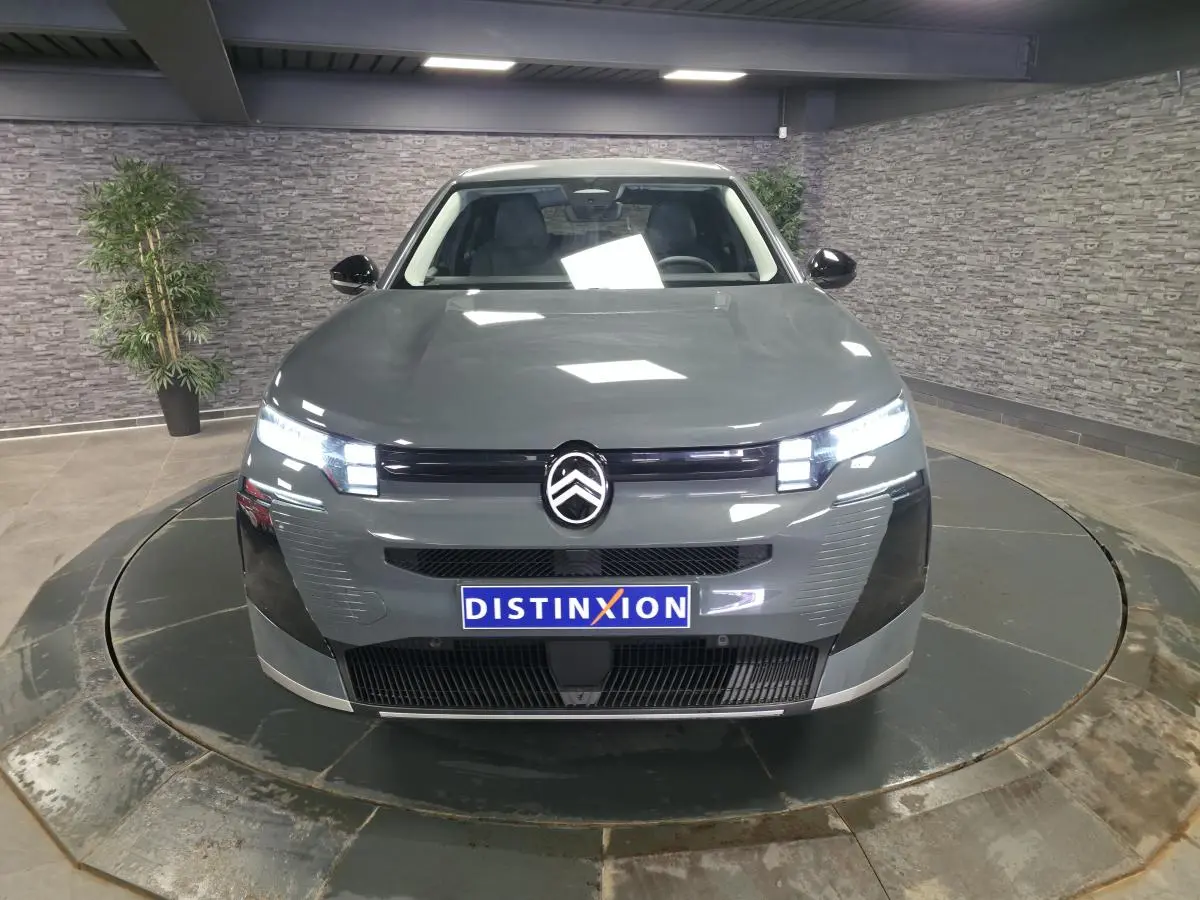 Vue avant d'une Citroën C5 Aircross 2026 gris métallisé avec calandre noire et feux LED allumés.