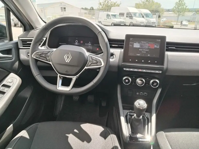 Vue intérieure avant centrée sur le volant multifonction et la console centrale avec écran tactile de la Renault Clio V TCE 90 Evolution.