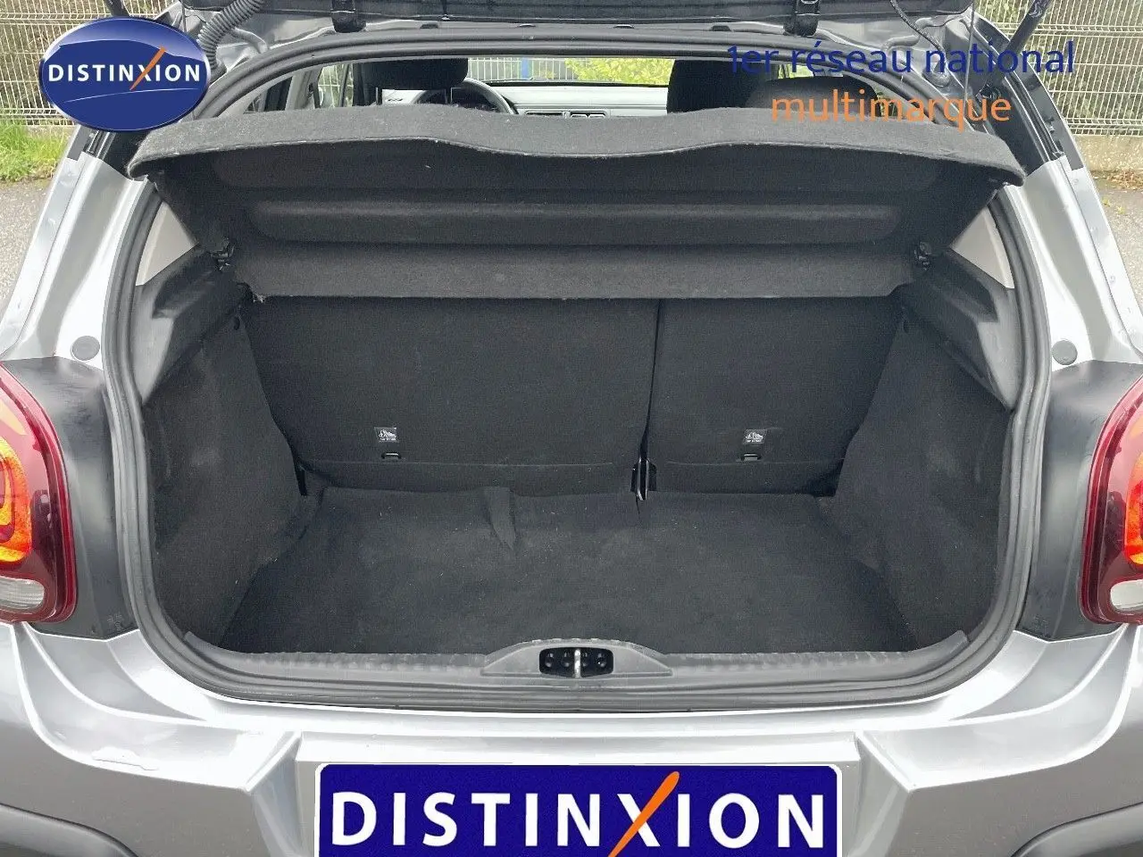 Coffre ouvert d'une Citroën C3 2023 gris acier métal avec toit noir, vue arrière montrant l'espace de chargement vide.