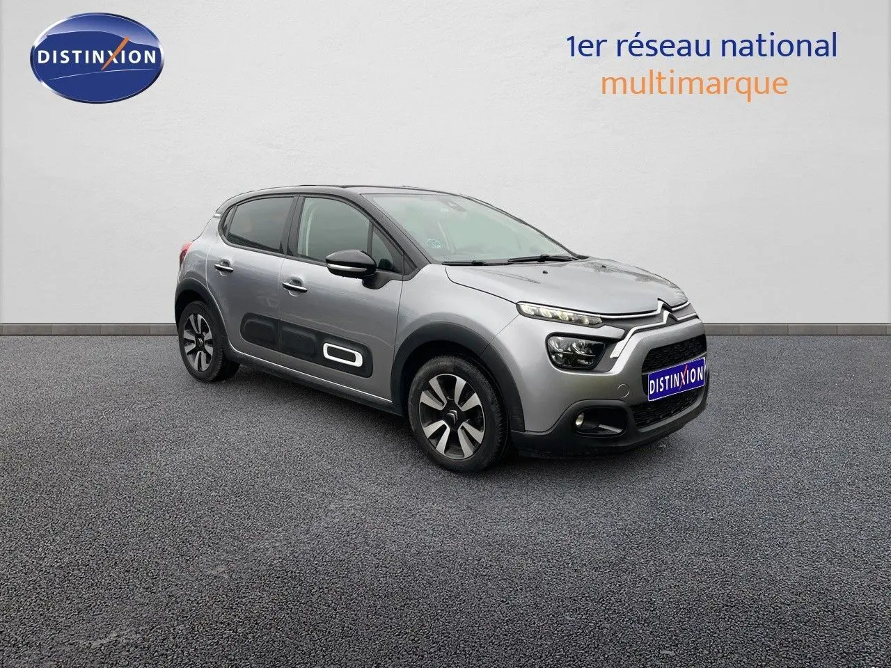 Citroën C3 gris acier métal avec toit noir vue 3/4 avant droit, soulignant les protections latérales et jantes bi-ton.