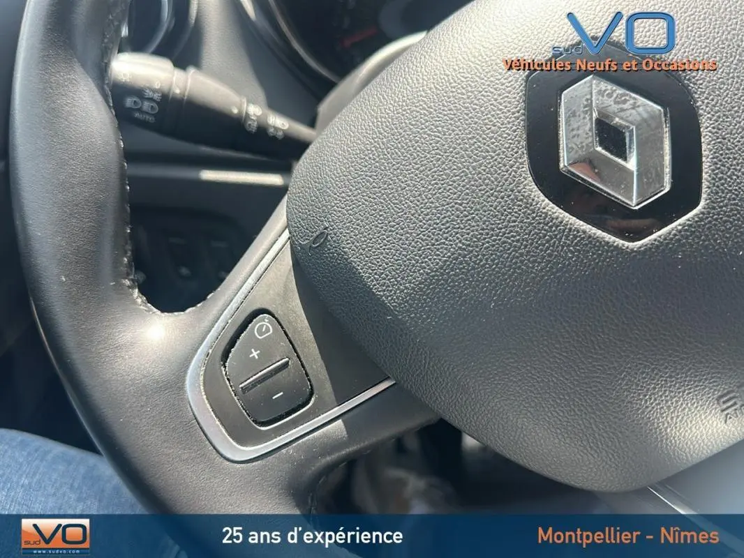 Gros plan sur le volant cuir du Renault Captur gris clair, montrant les commandes de régulateur de vitesse à gauche.