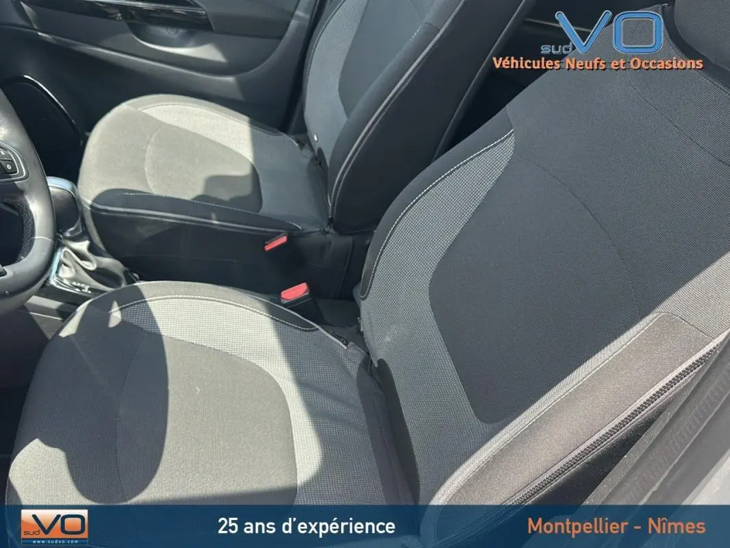 Vue rapprochée des sièges avant en tissu gris du Renault Captur TCe 120 Energy Zen EDC 2016, intérieur sobre et fonctionnel.