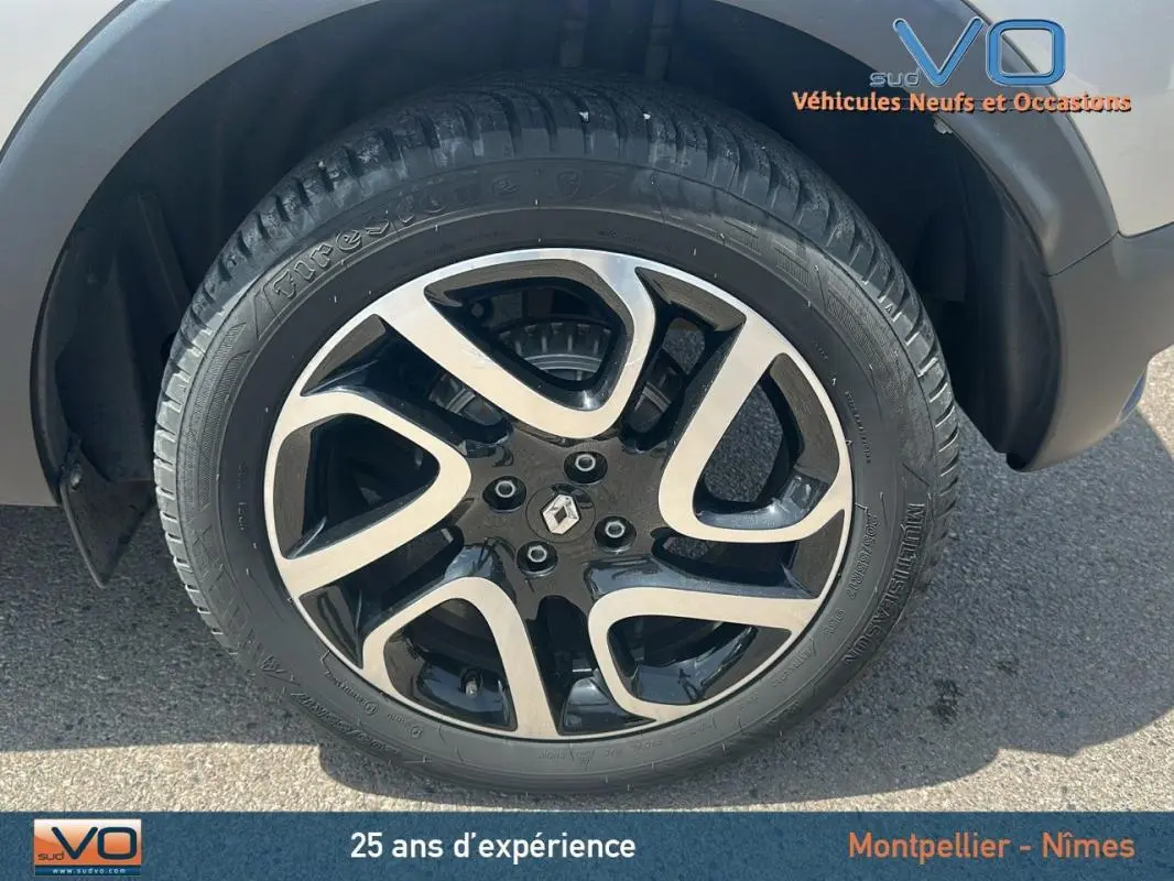 Gros plan sur la jante alliage 16 pouces noire et argentée du Renault Captur gris clair côté droit.