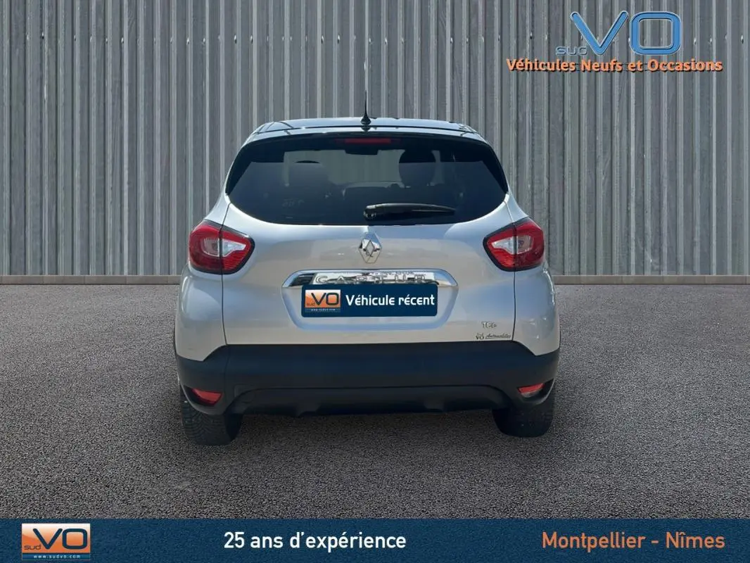 Vue arrière d'un Renault Captur gris clair TCe 120 Energy Zen EDC de 2016 avec feux arrière et lunette teintée.