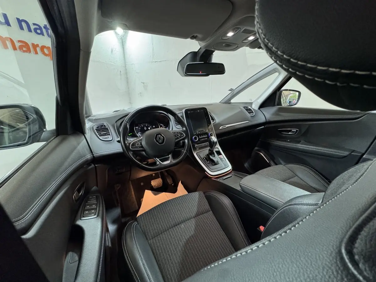 Intérieur du Renault Scénic Intens 2021 vu côté conducteur, tableau de bord moderne avec écran tactile central et sièges noirs.