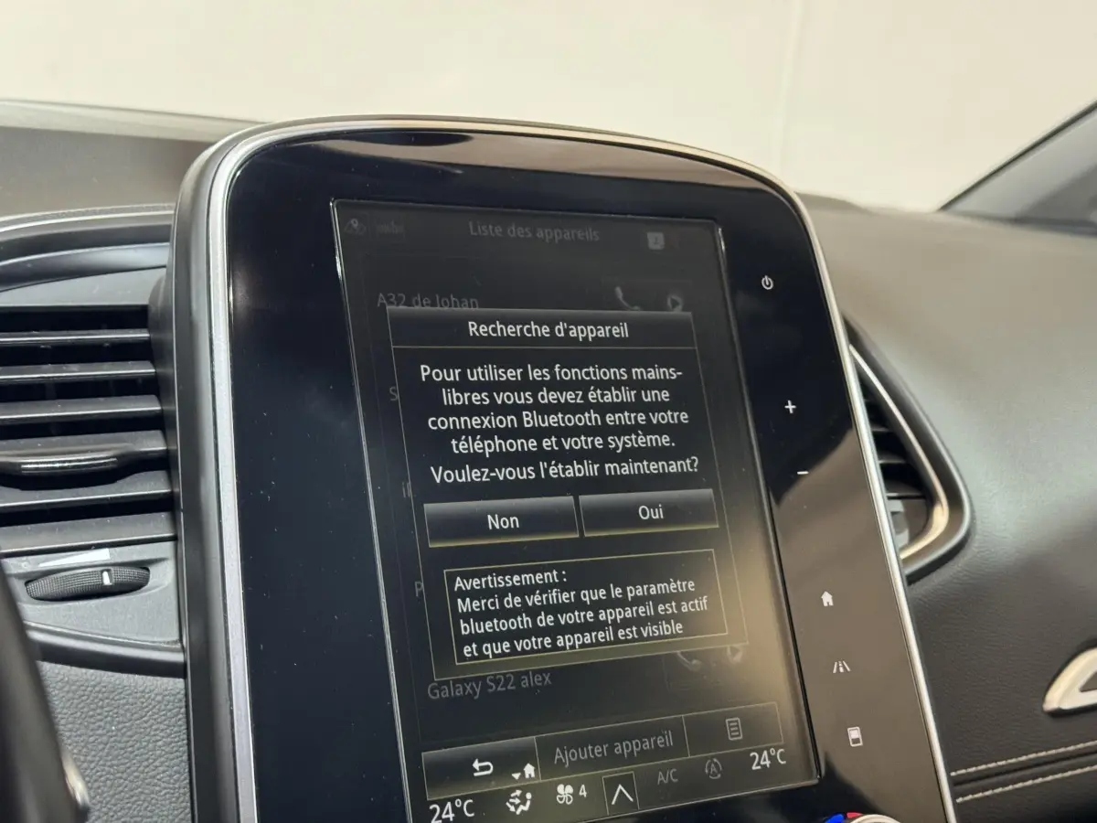 Écran tactile central affichant la connexion Bluetooth dans l’habitacle gris du Renault Scénic Intens rouge.