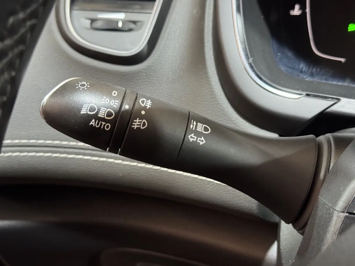 Gros plan sur la commande des phares et clignotants dans l'habitacle du Renault Scénic Intens rouge 2021.