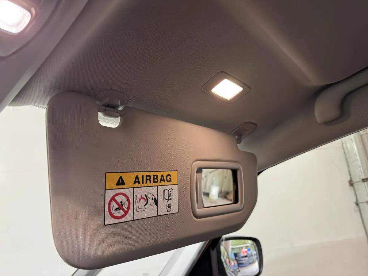 Pare-soleil intérieur côté gauche avec avertissement airbag et miroir, dans un Renault Scenic rouge 2021 Intens TCe 160 EDC.