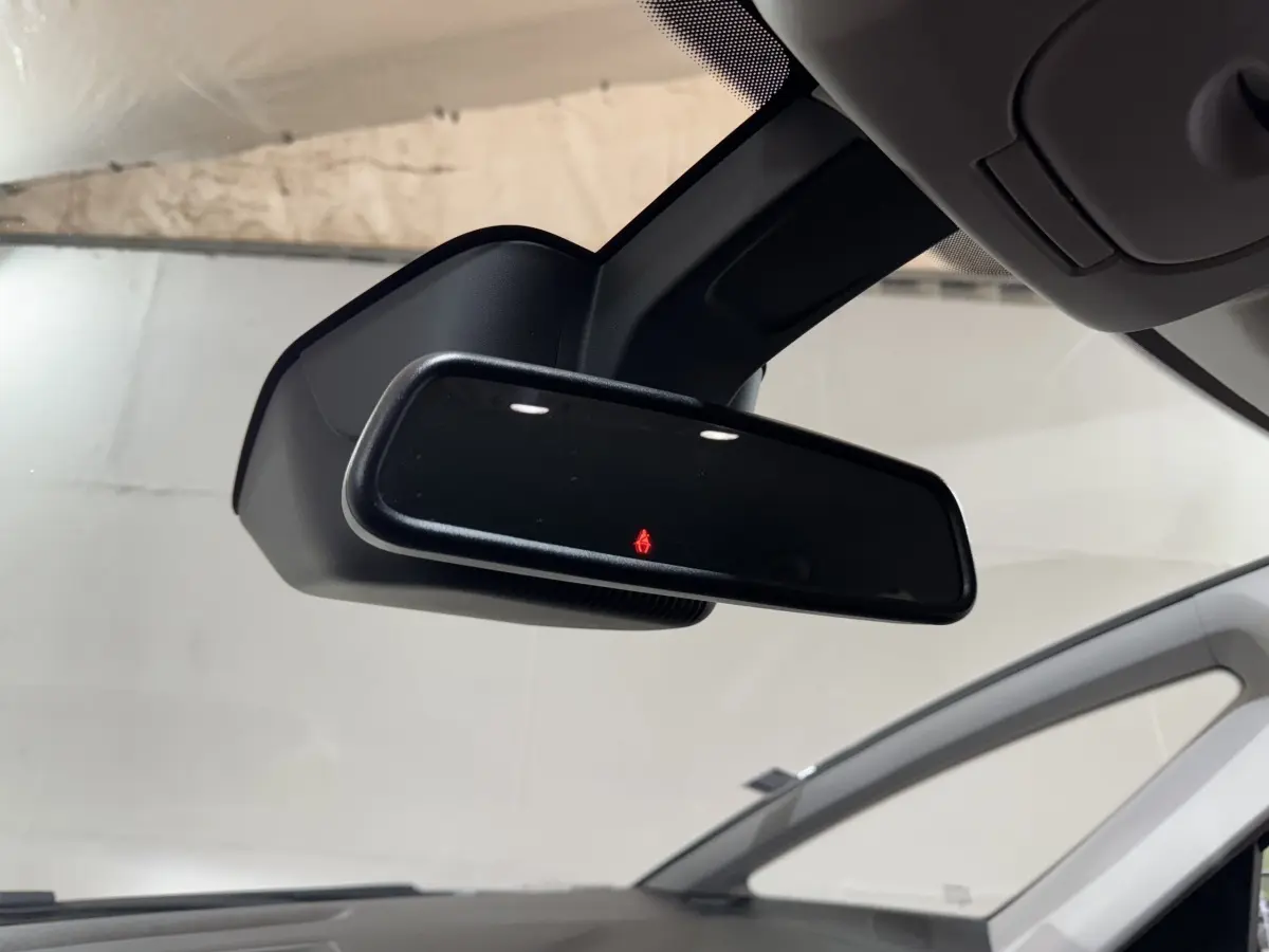 Rétroviseur intérieur noir avec témoin de ceinture allumé, vue depuis l'habitacle du Renault Scénic rouge.