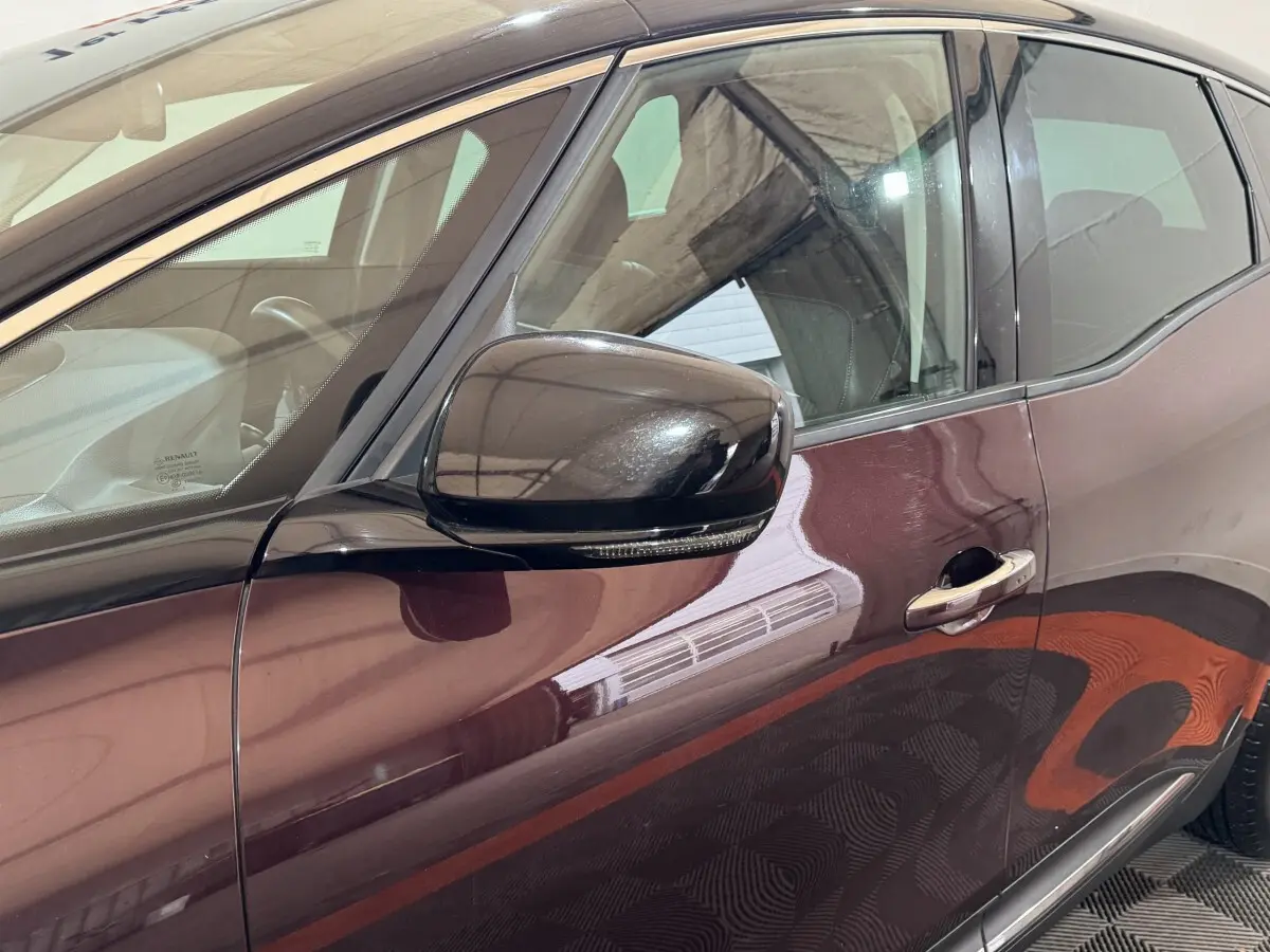 Vue côté gauche rapprochée du Renault Scénic Intens rouge 2021 avec rétroviseur noir et poignée chromée.