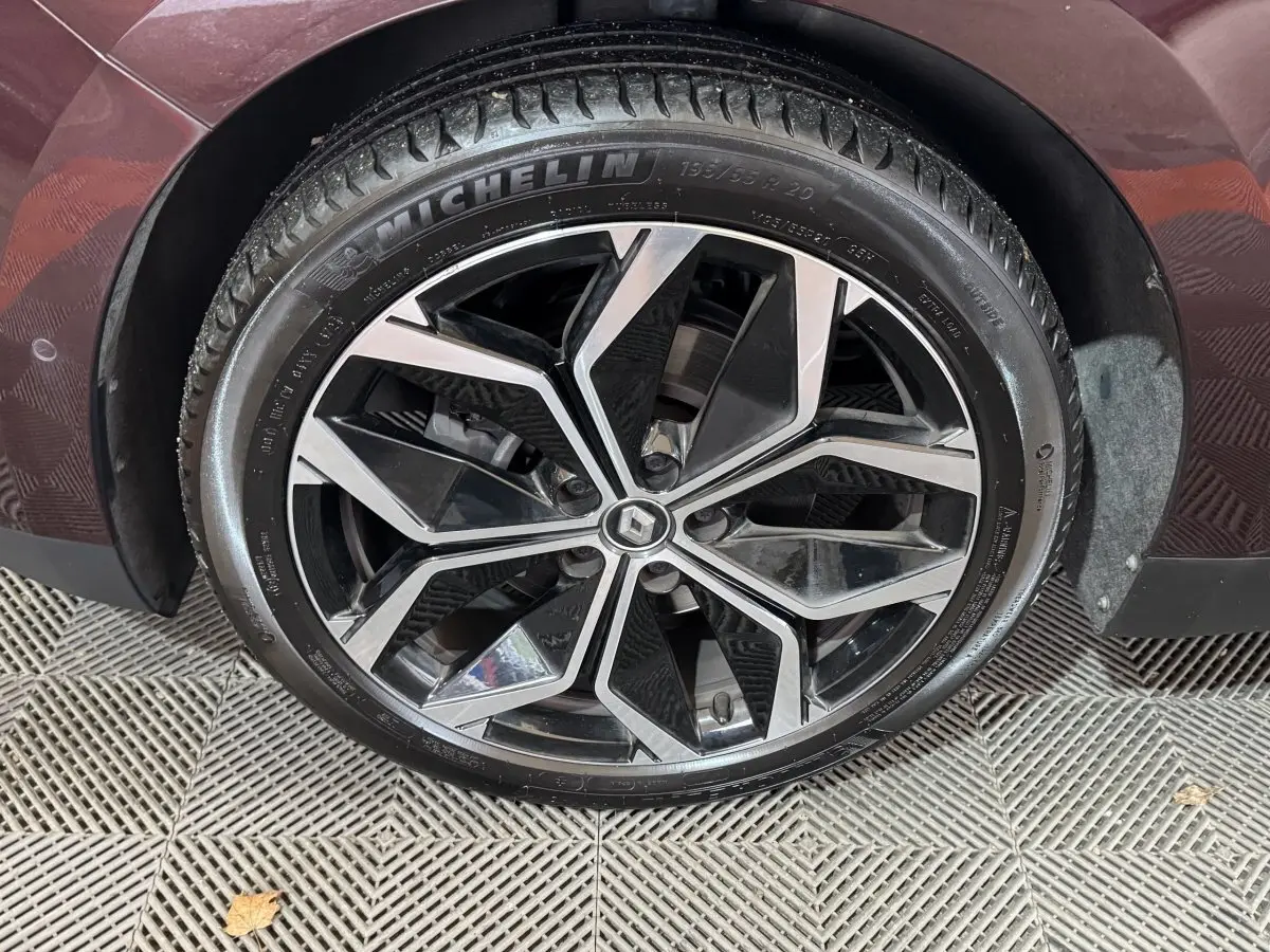 Gros plan sur la roue avant droite rouge du Renault Scenic Intens 2021 avec jante alliage noir et argentée.