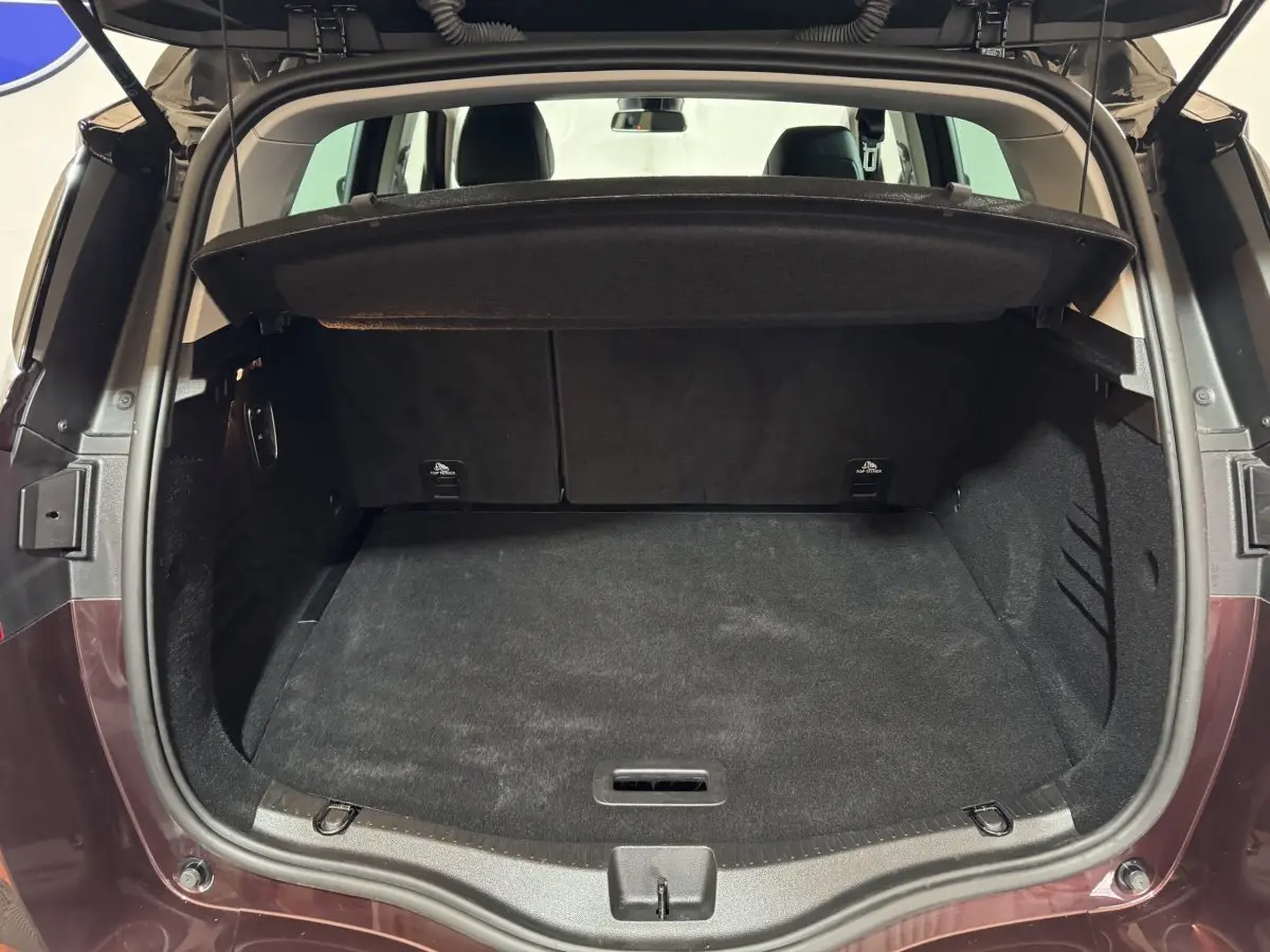 Coffre ouvert d'un Renault Scénic Intens rouge 2021, vue arrière montrant l'espace de chargement et la tablette cache-bagages.