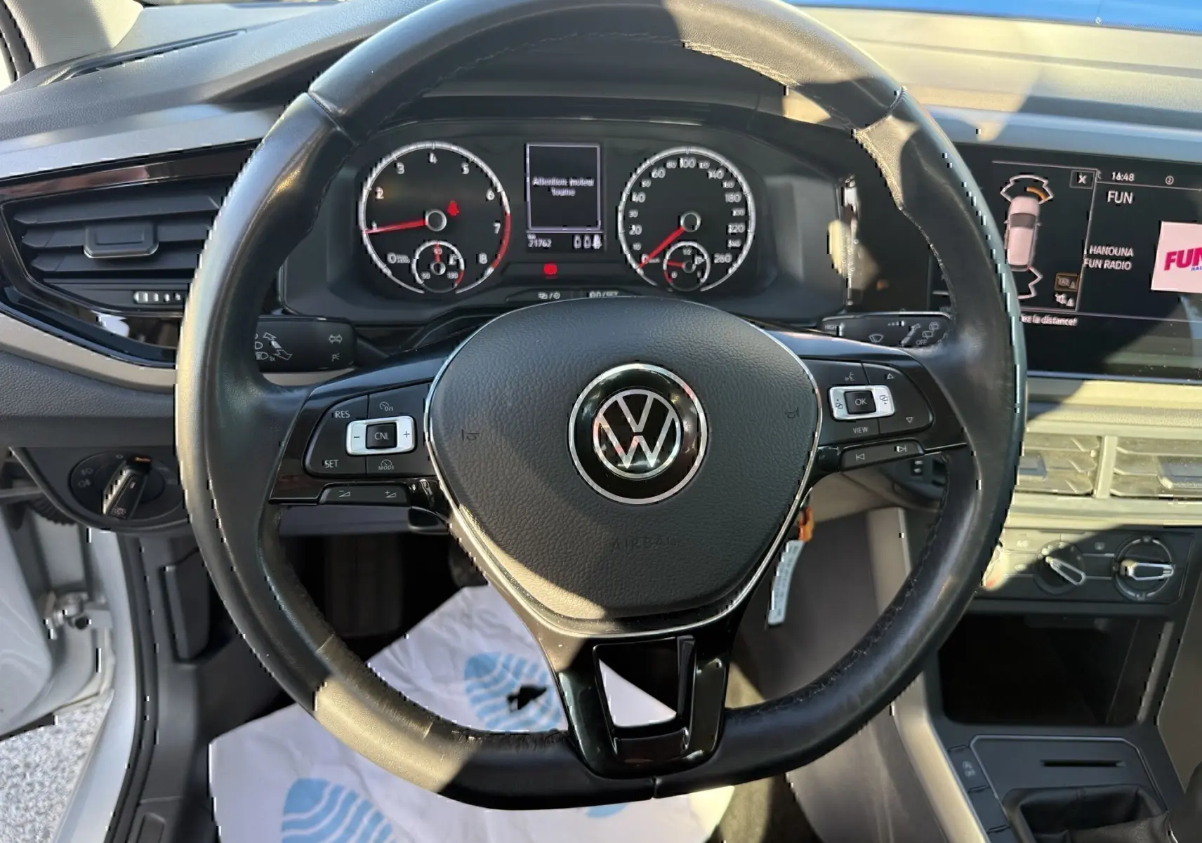 Vue intérieure centrée sur le volant noir de la Volkswagen Polo 2021, avec tableau de bord et écran multimédia visibles.