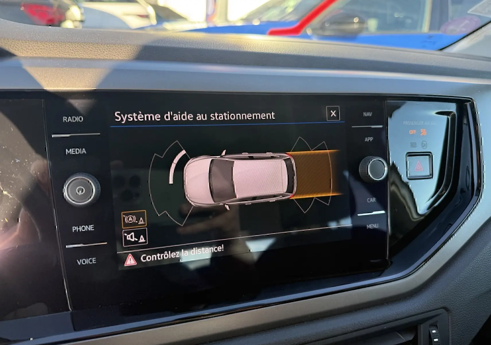 Écran central du Volkswagen Polo 2021 gris métal montrant le système d'aide au stationnement en vue de dessus.