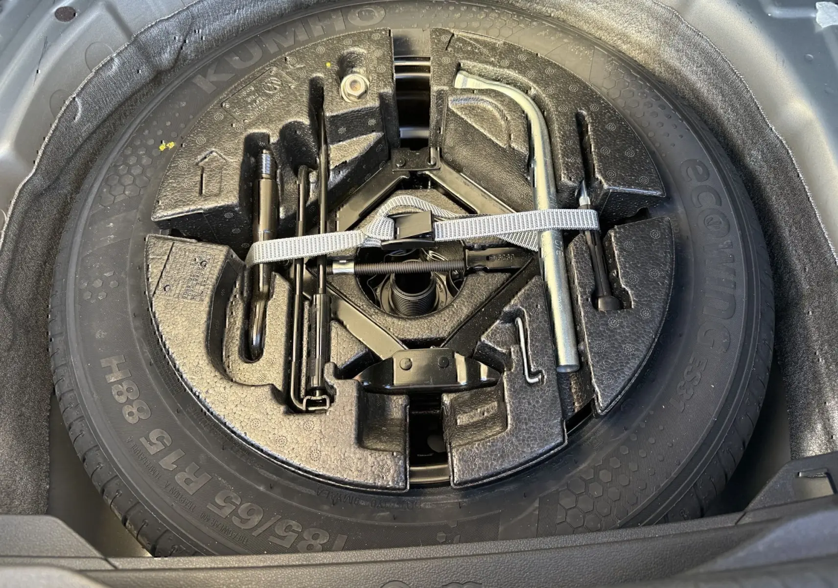 Gros plan sur la roue de secours et les outils de bord dans le coffre d'une Volkswagen Polo gris métal 2021.