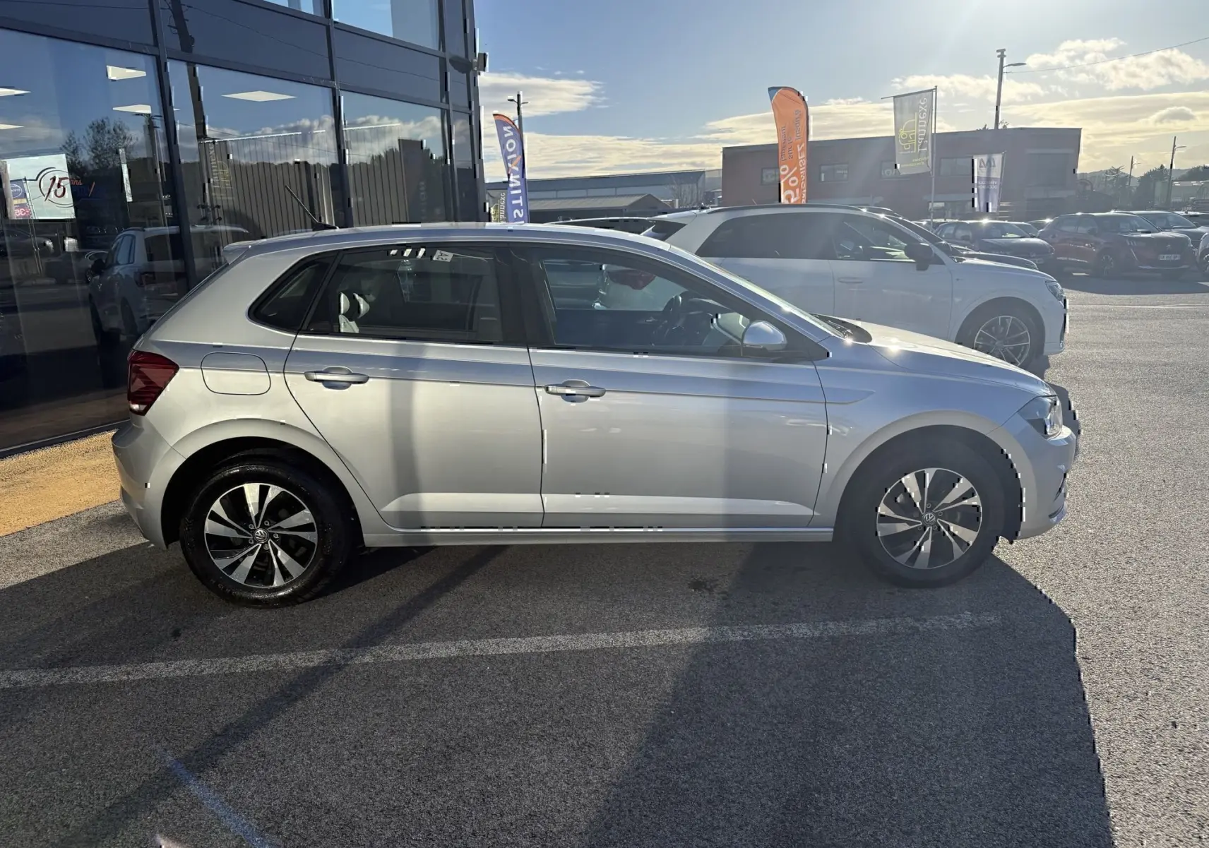 Vue de profil côté gauche d'une Volkswagen Polo gris métal 2021, avec jantes alliage bicolores et vitres teintées.