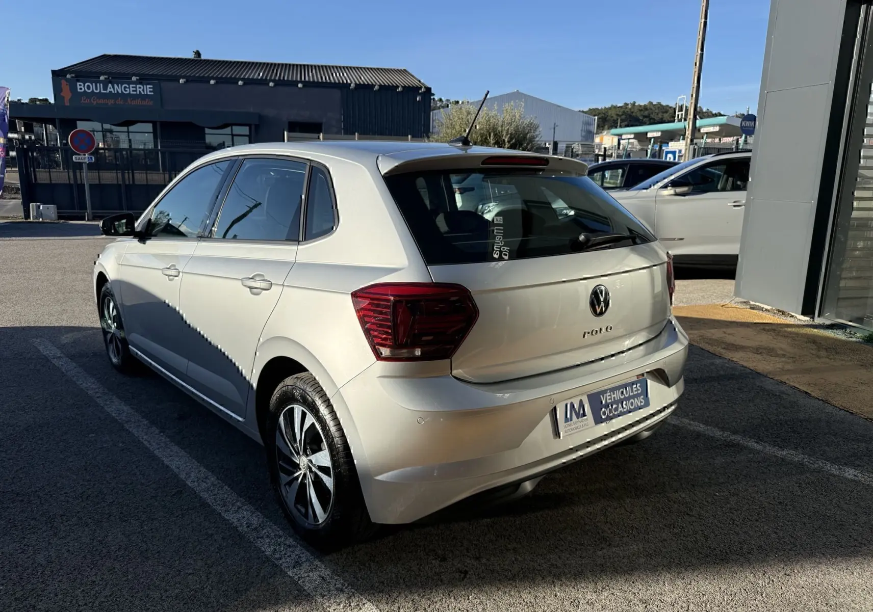 Vue 3/4 arrière droite d'une Volkswagen Polo gris métal 2021 avec feux arrière foncés et jantes alliage.