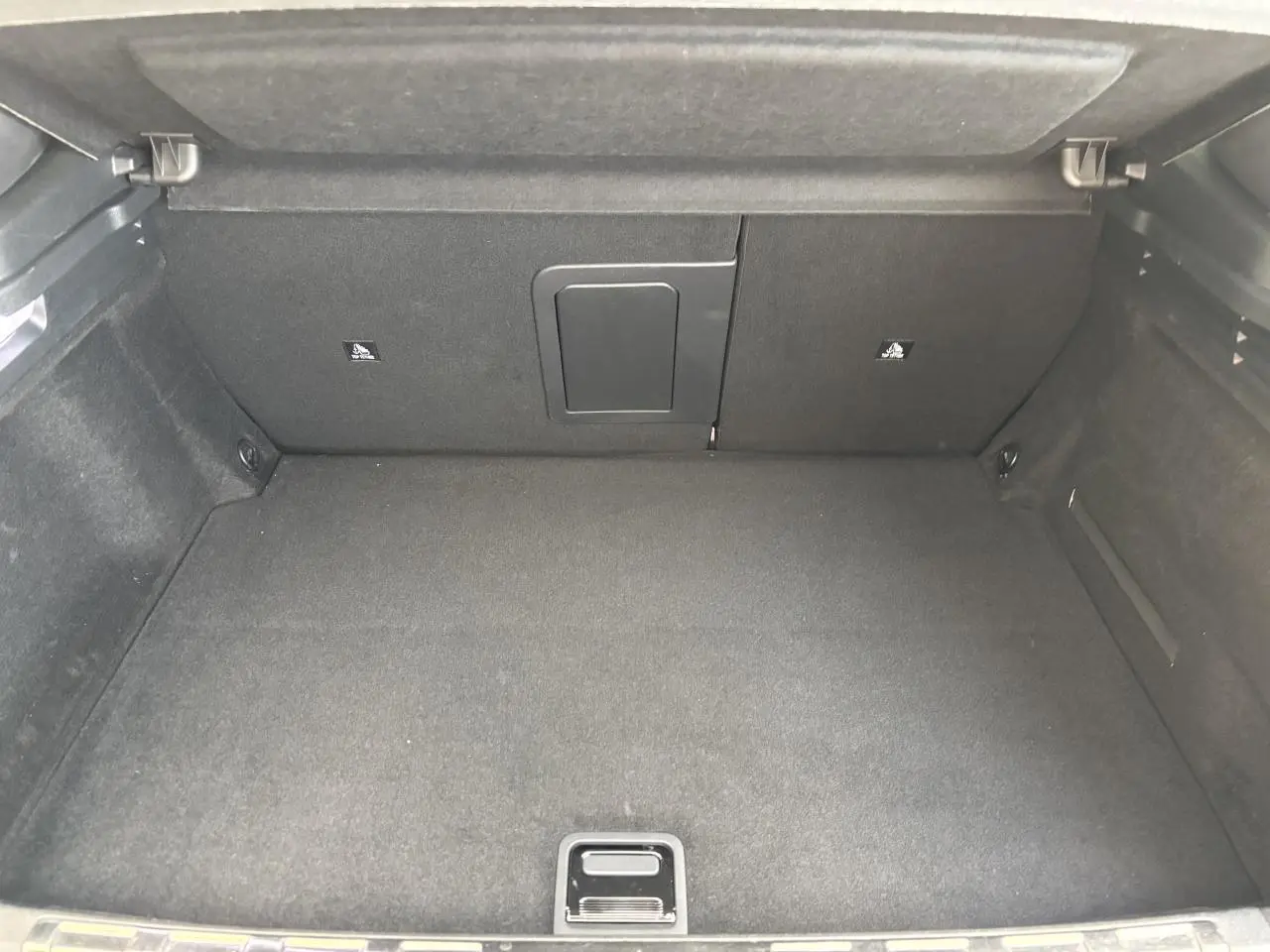 Coffre vide vu de face du DS4 E-Tense 2023, revêtement intérieur noir avec trappe centrale au fond.