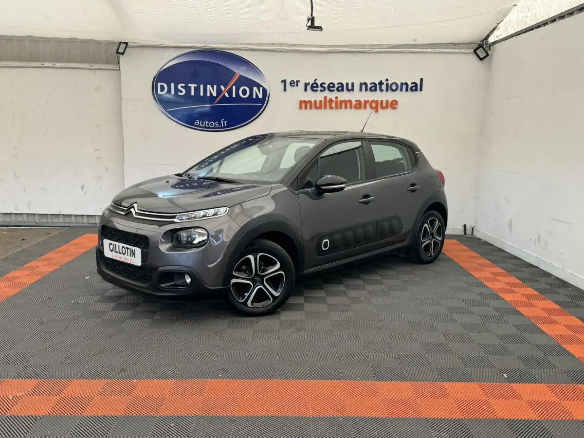Citroën C3 gris foncé vue 3/4 avant droit, avec protections latérales Airbump et jantes spécifiques.