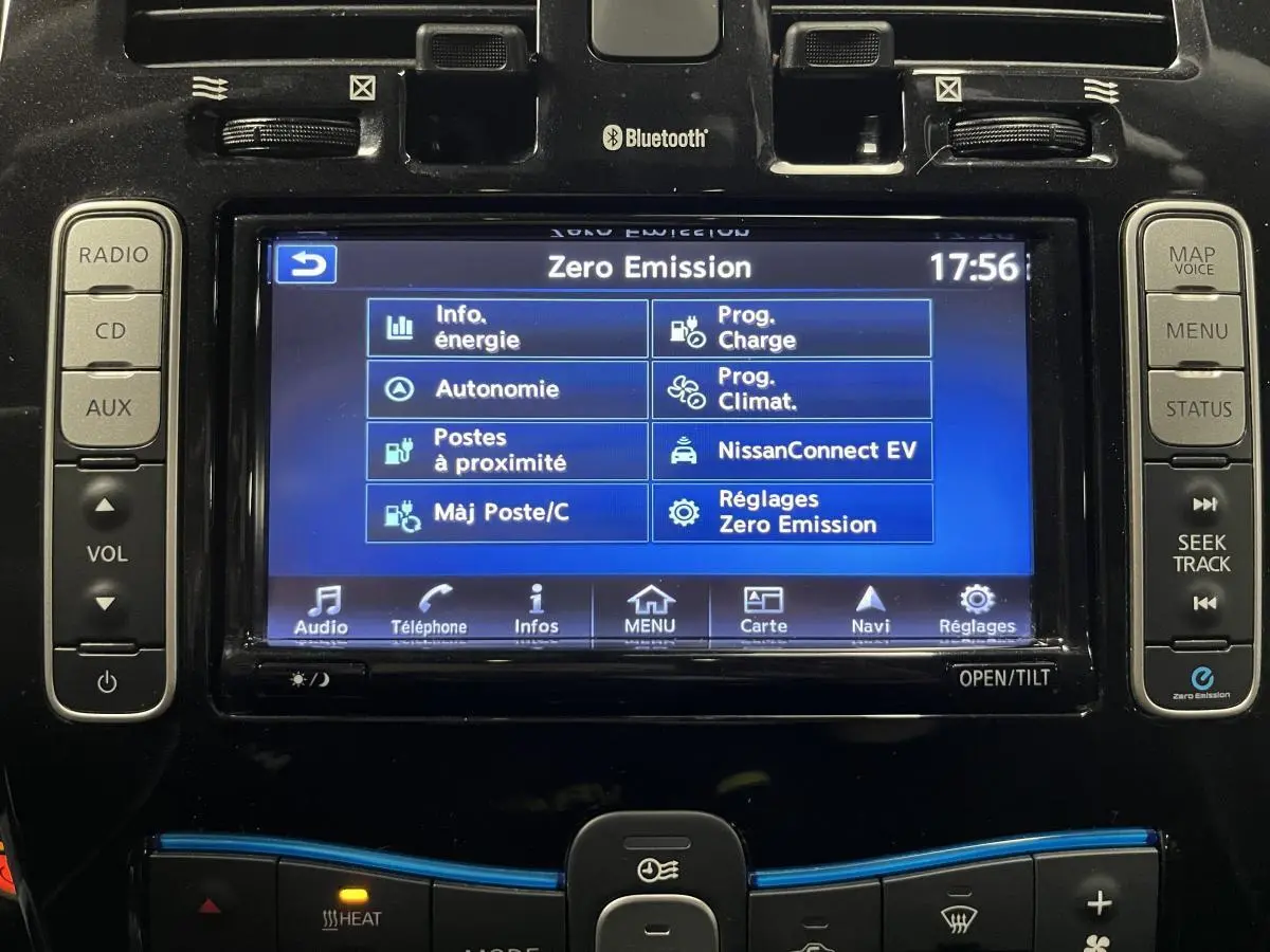 Écran tactile central de la Nissan Leaf 2017 rouge affichant le menu Zero Emission avec commandes audio et climatisation.