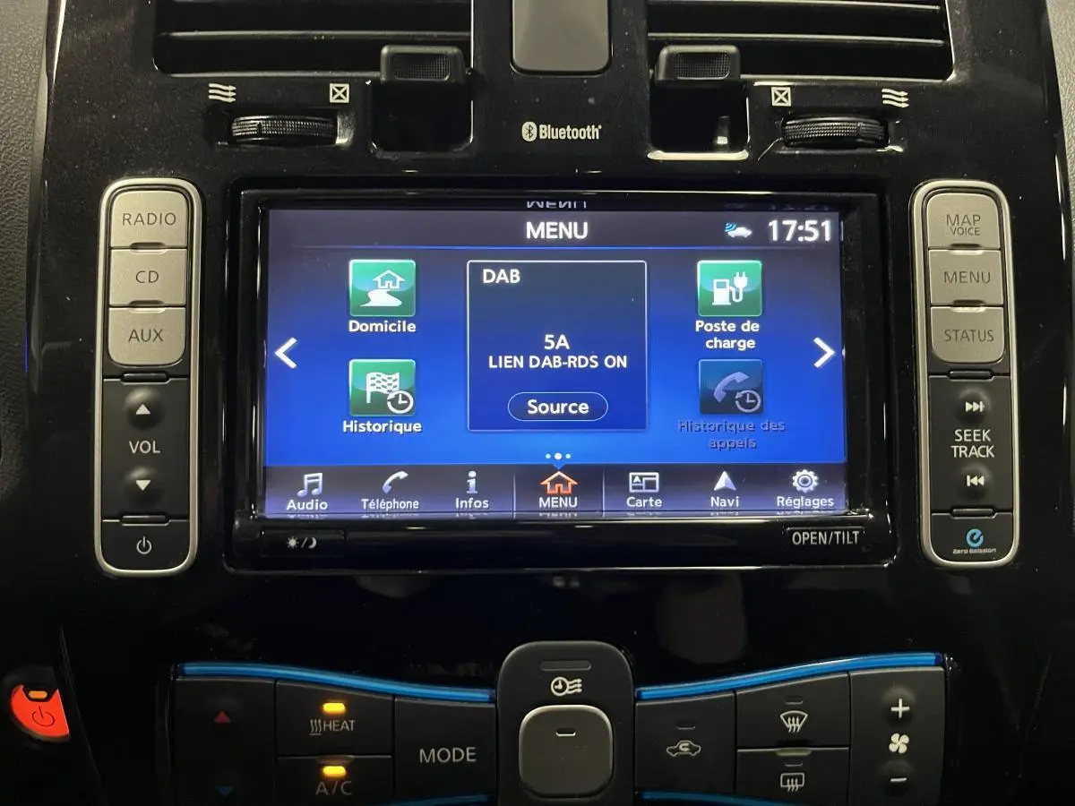 Vue rapprochée de la console centrale du Nissan Leaf rouge 2017, affichant l'écran tactile multimédia et les commandes climatisation.