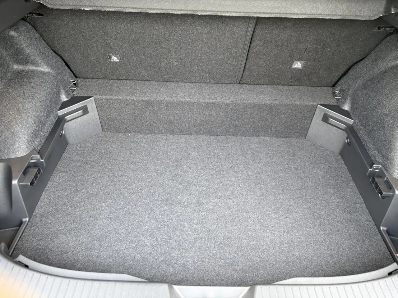 Vue plongeante sur le coffre spacieux et propre du Nissan Qashqai III gris Ceramic, sans chargement visible.