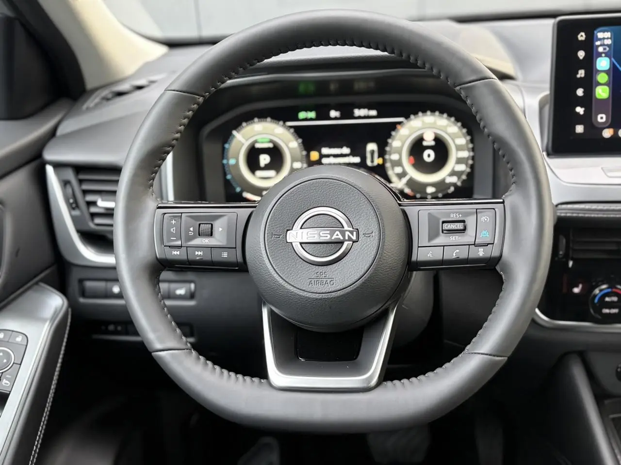 Vue rapprochée du volant cuir noir du Nissan Qashqai 2025 avec tableau de bord numérique et écran tactile visible.