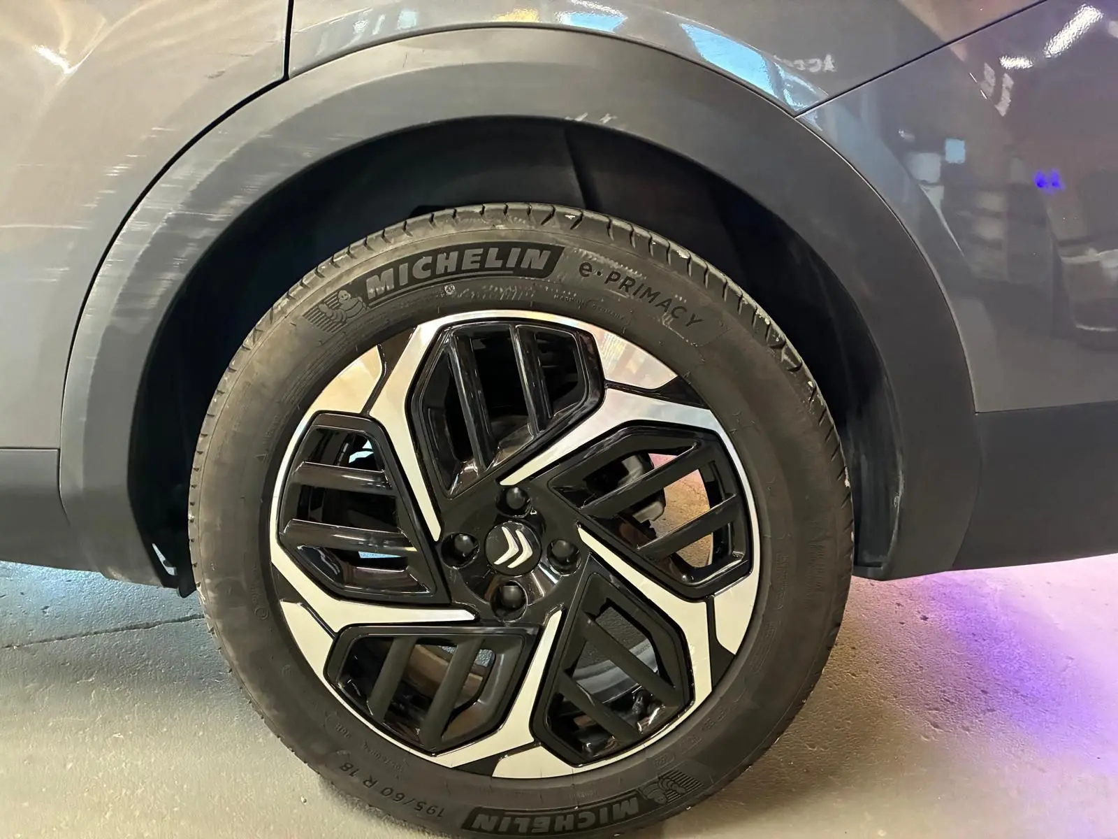 Gros plan sur la roue avant droite d'une Citroën C4 X gris 2024 avec jante alliage noire et argentée distinctive.