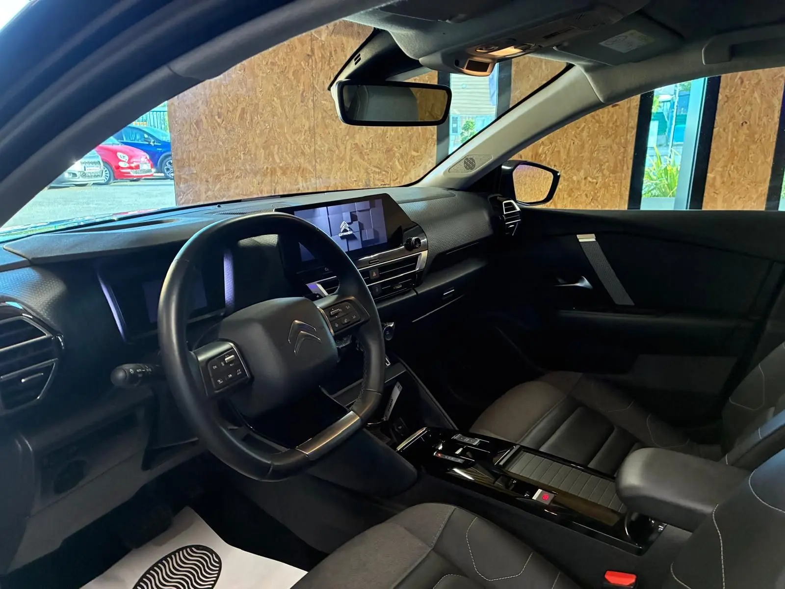 Vue intérieure côté conducteur du Citroën C4 X gris 2024, mettant en valeur le tableau de bord moderne et l'écran tactile central.