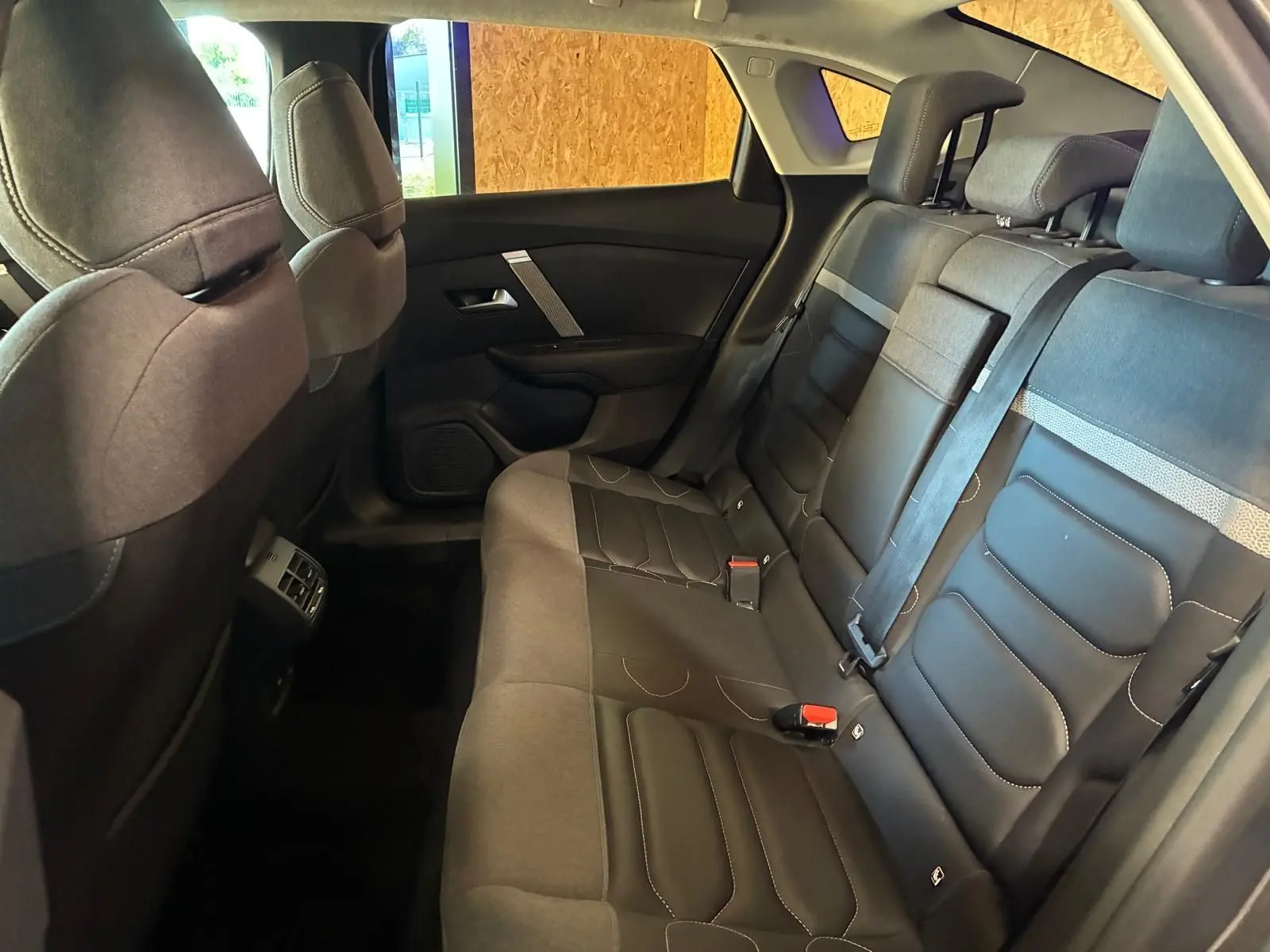 Vue intérieure côté droit des sièges arrière en tissu gris noir de la Citroën C4 X 2024, version diesel 1.5 BlueHDi.