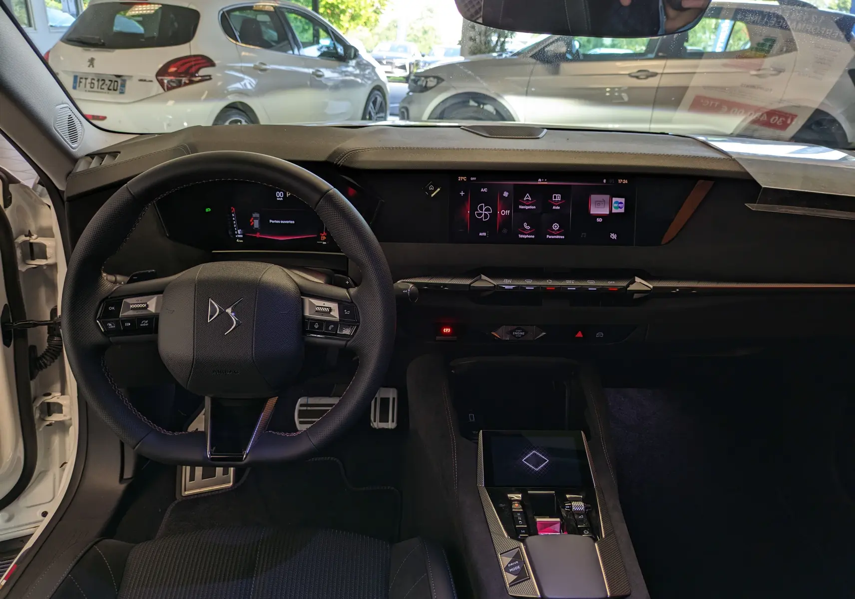 Vue intérieure du poste de conduite du DS4 blanc nacré 2024, avec volant compact, écran tactile central et finitions Alcantara® élégantes.