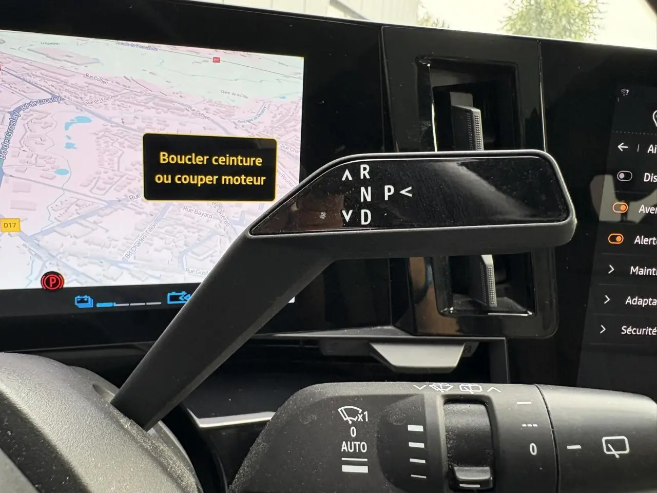 Le levier de vitesses automatique et commandes d'essuie-glace du Renault Espace E-Tech 2023, avec écran tactile en arrière-plan.