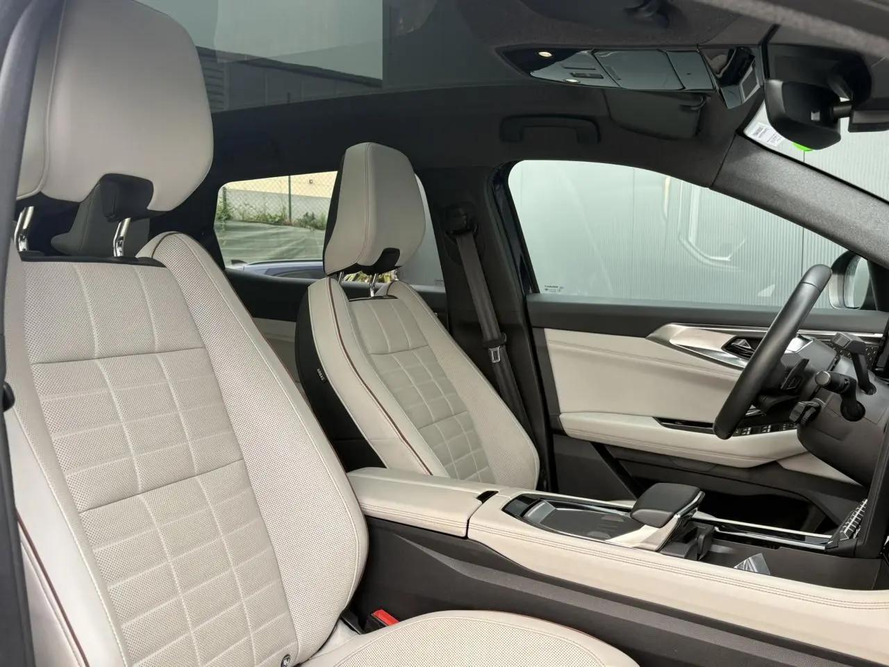 Intérieur côté conducteur du Renault Espace 2023, sièges cuir gris sable clair et toit panoramique visible