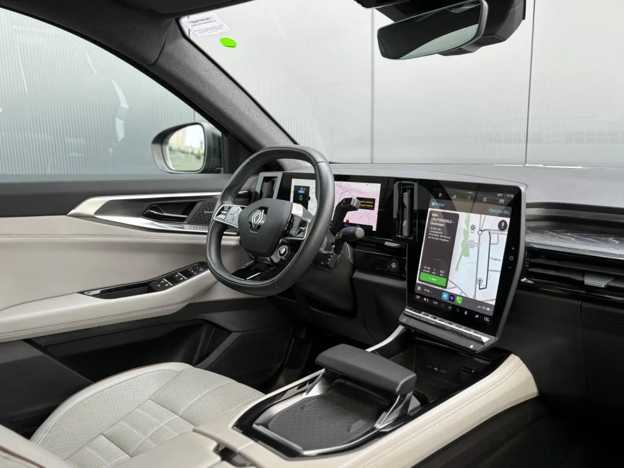 Vue intérieure côté conducteur du Renault Espace hybride 2023, avec sellerie cuir beige et écran tactile central vertical.