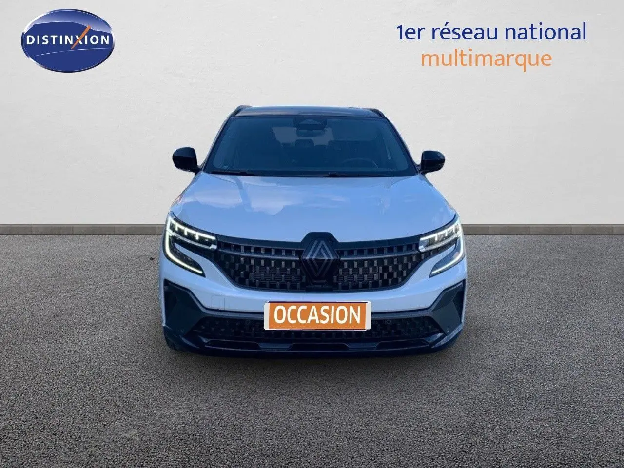 Vue frontale d'un Renault Austral 2024 blanc métal avec toit noir et calandre noire distinctive.