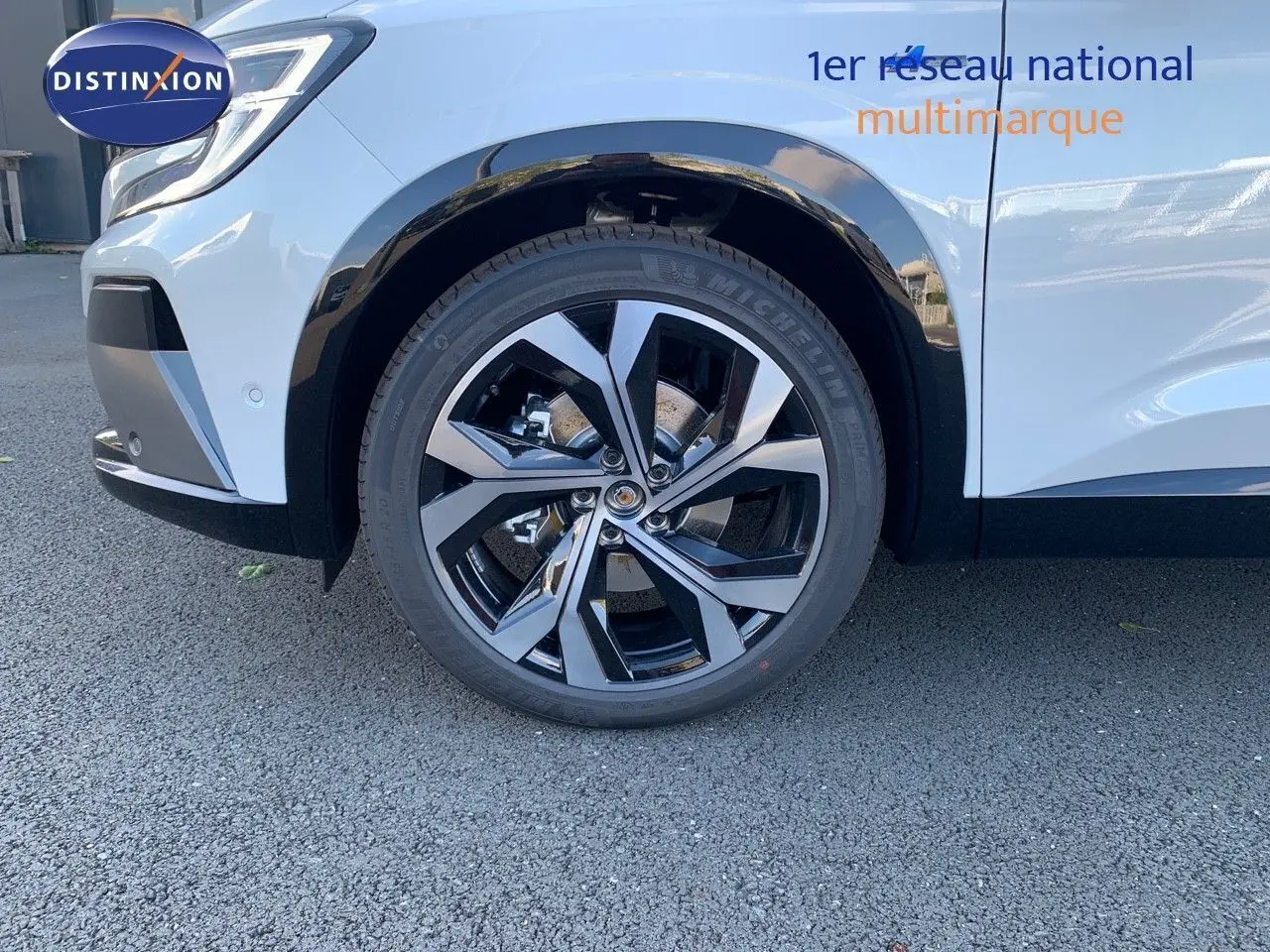 Gros plan sur la roue avant droite du Renault Austral blanc métal avec jante alliage noire et argentée.