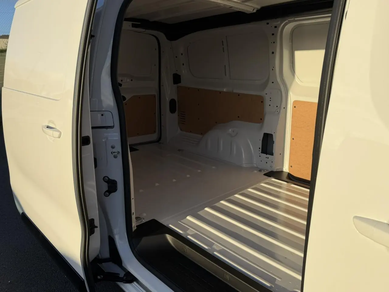 Vue intérieure de la zone de chargement du Citroën Jumpy XL blanc Icy, avec porte latérale droite ouverte.