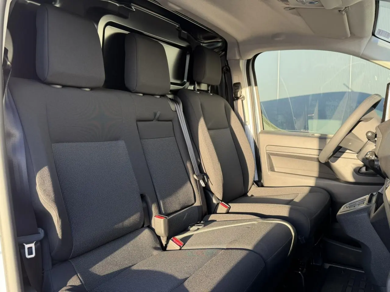 Intérieur du Citroën Jumpy XL 2025 vu côté droit, montrant la banquette passager noire et le siège conducteur.