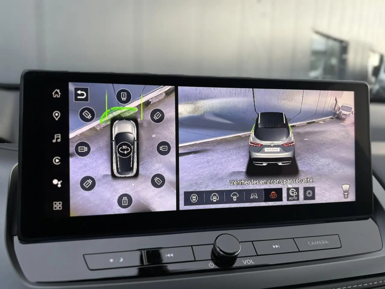 Écran intérieur affichant la vue 3D et arrière du Nissan Qashqai gris Ceramic en stationnement.