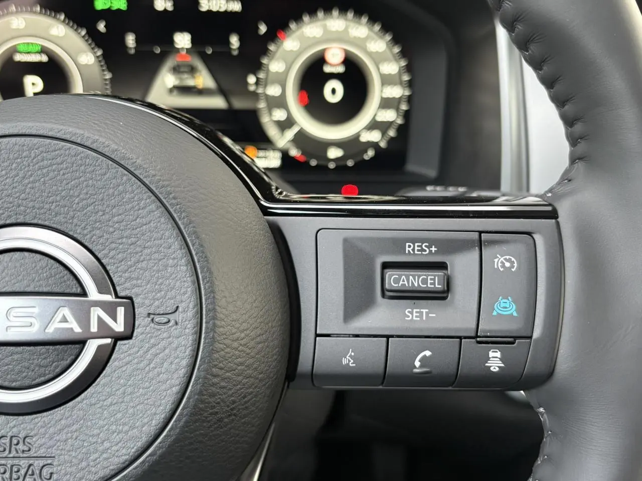 Gros plan sur le volant cuir noir du Nissan Qashqai 2025, avec commandes de régulateur et assistance à la conduite.