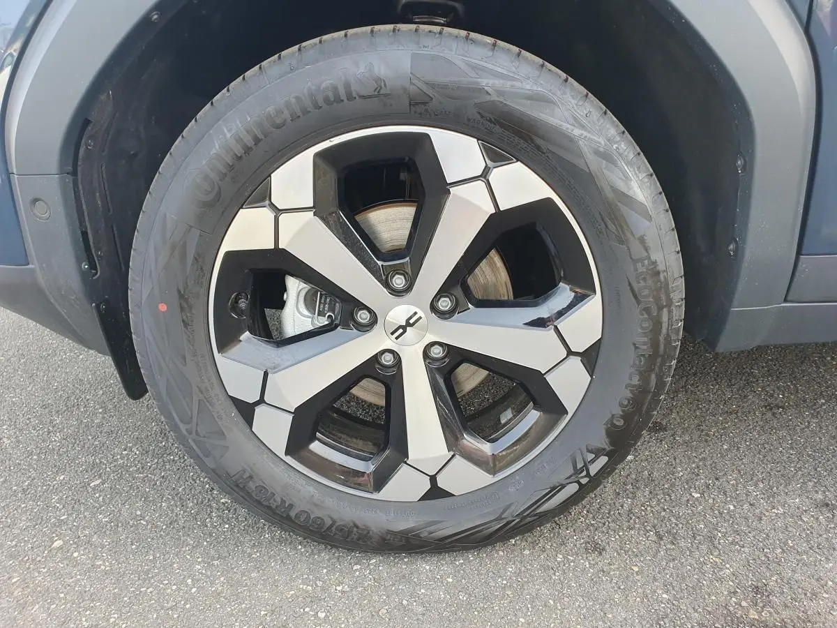 Gros plan sur la jante alliage 18” diamantée Tagasan du côté avant droit du Dacia Bigster bleu indigo.