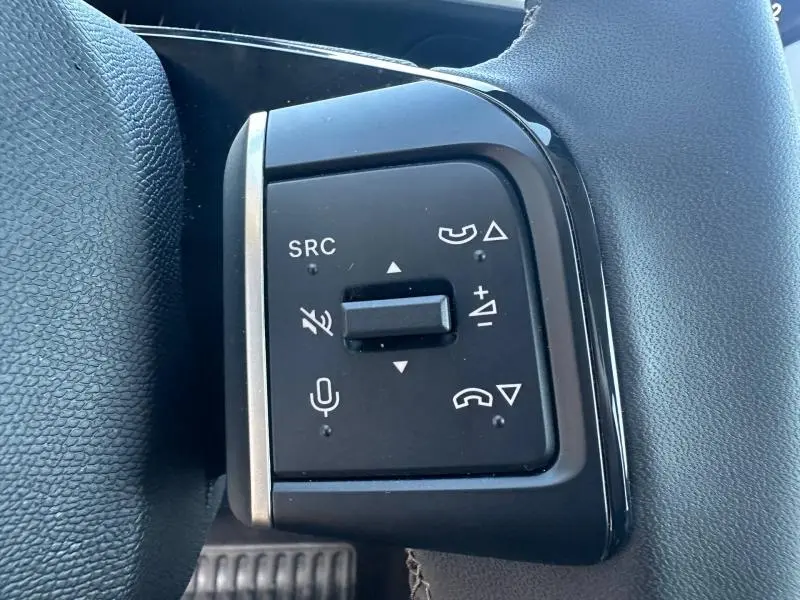 Gros plan sur les commandes noires du volant côté gauche du Citroën C3 1.2 Turbo 100ch MAX 2025, avec boutons multifonctions.