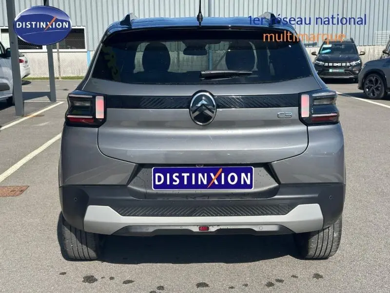 Vue arrière d'une Citroën C3 2025 noire avec feux arrière distinctifs et logo central sur un parking.