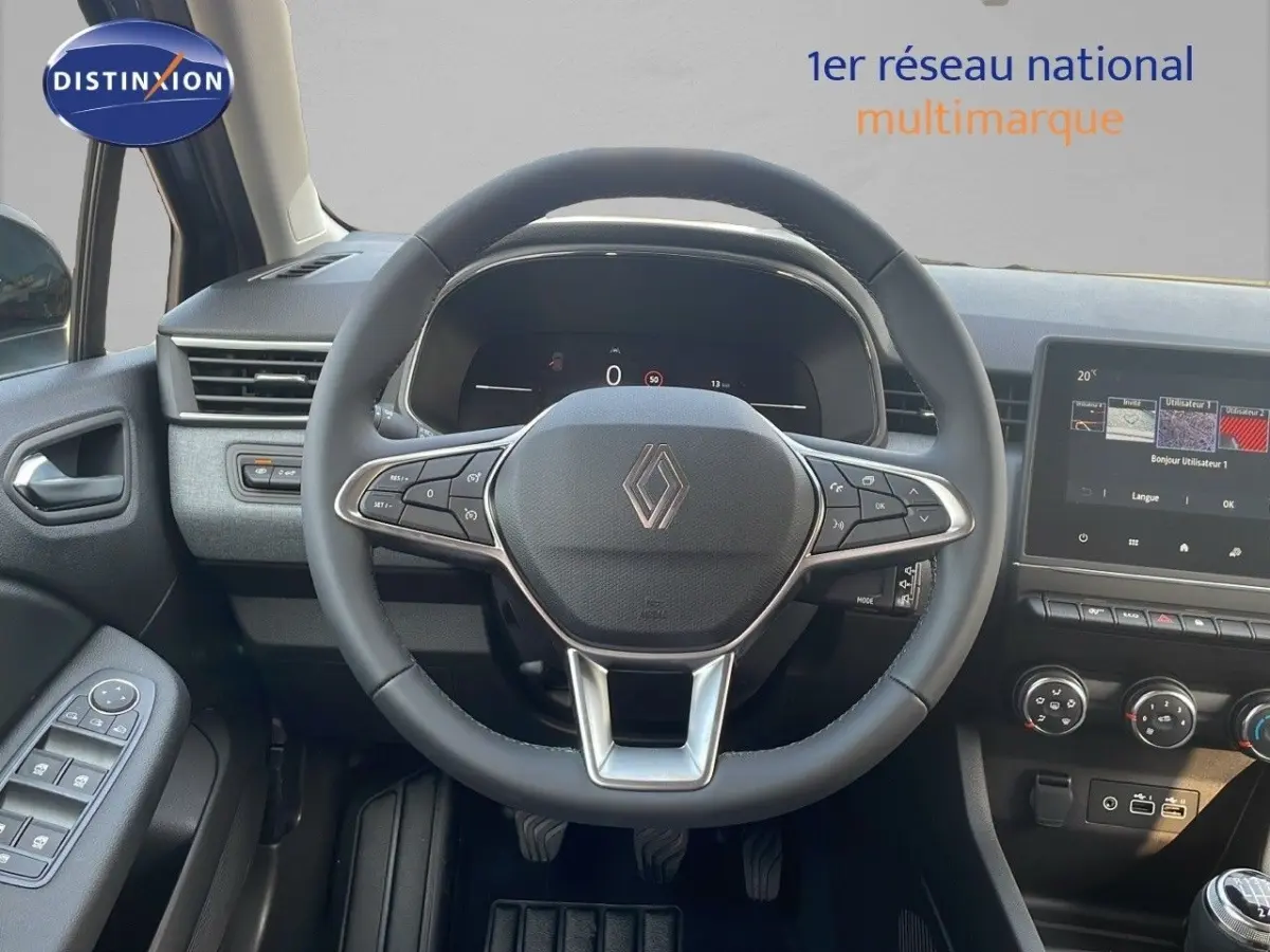 Vue intérieure centrée sur le volant cuir noir et le tableau de bord numérique de la Renault Clio Evolution 2025.