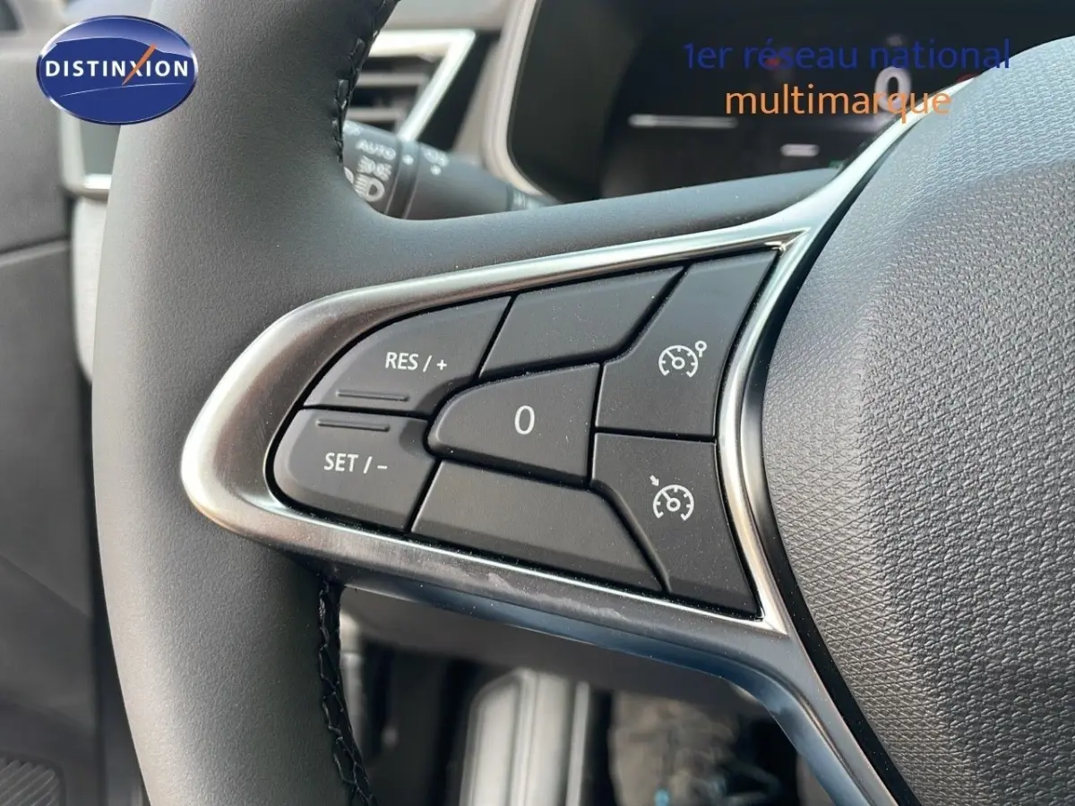 Gros plan sur les commandes du régulateur de vitesse au volant cuir noir d'une Renault Clio Evolution Blue dCi 2025.