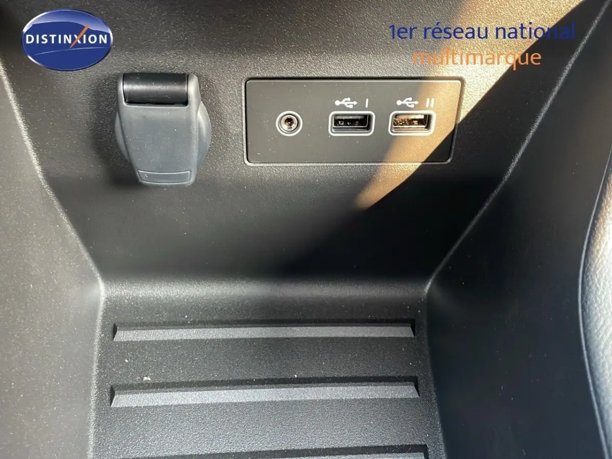 Prise USB double et prise 12V dans le compartiment central noir intérieur de la Renault Clio Evolution Blue dCi 2025.