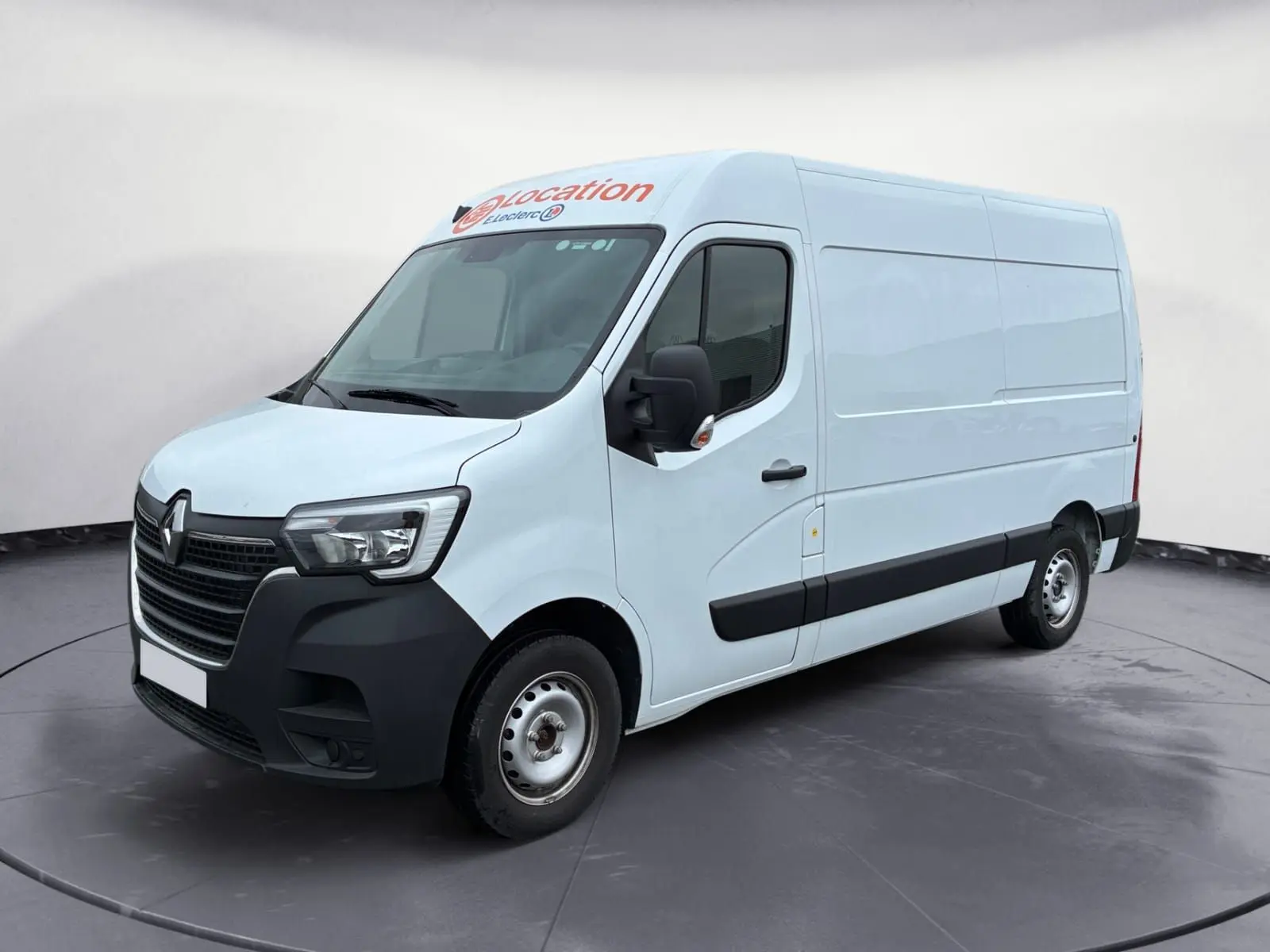 Vue 3/4 avant droit d’un Renault Master blanc 2024 utilitaire avec marquage "location" sur le toit.