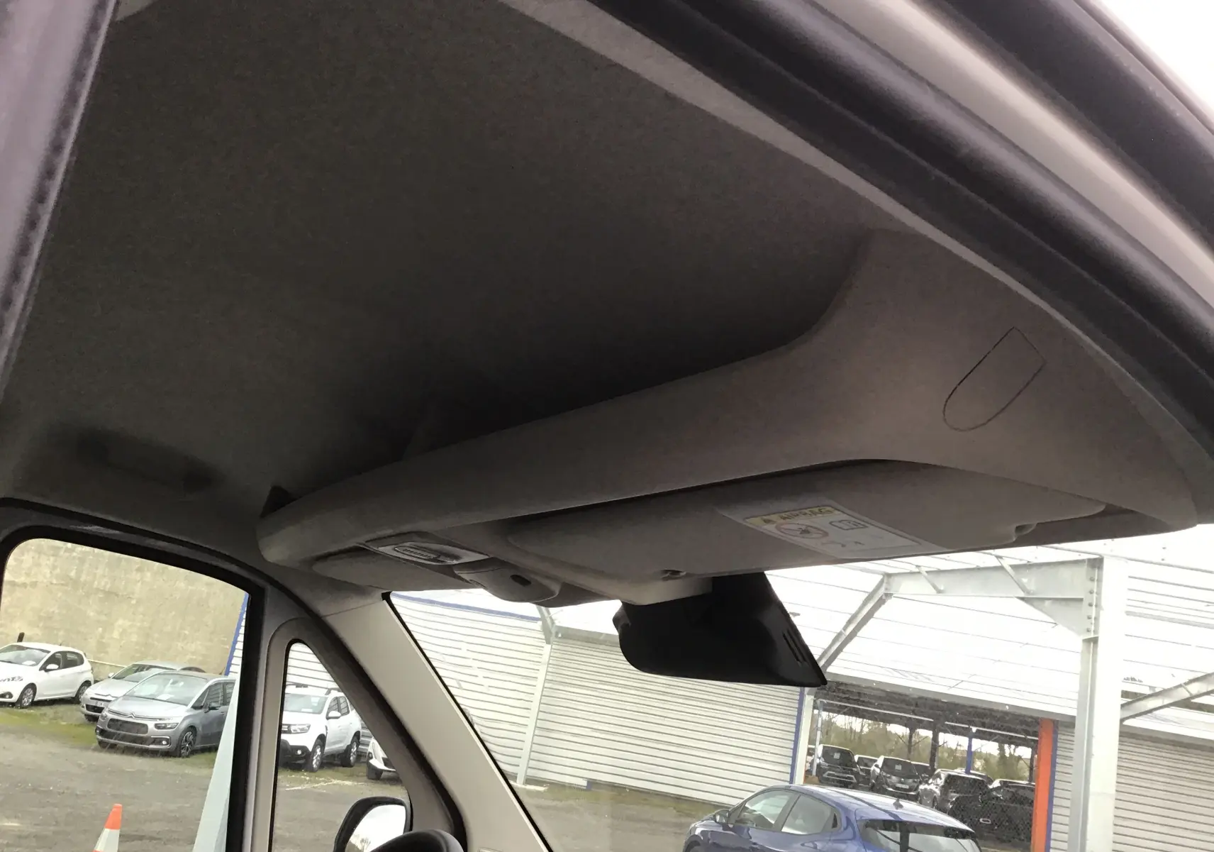 Vue intérieure du plafond et pare-soleil côté conducteur du Peugeot Boxer Fourgon blanc 2025, avec rétroviseur visible.