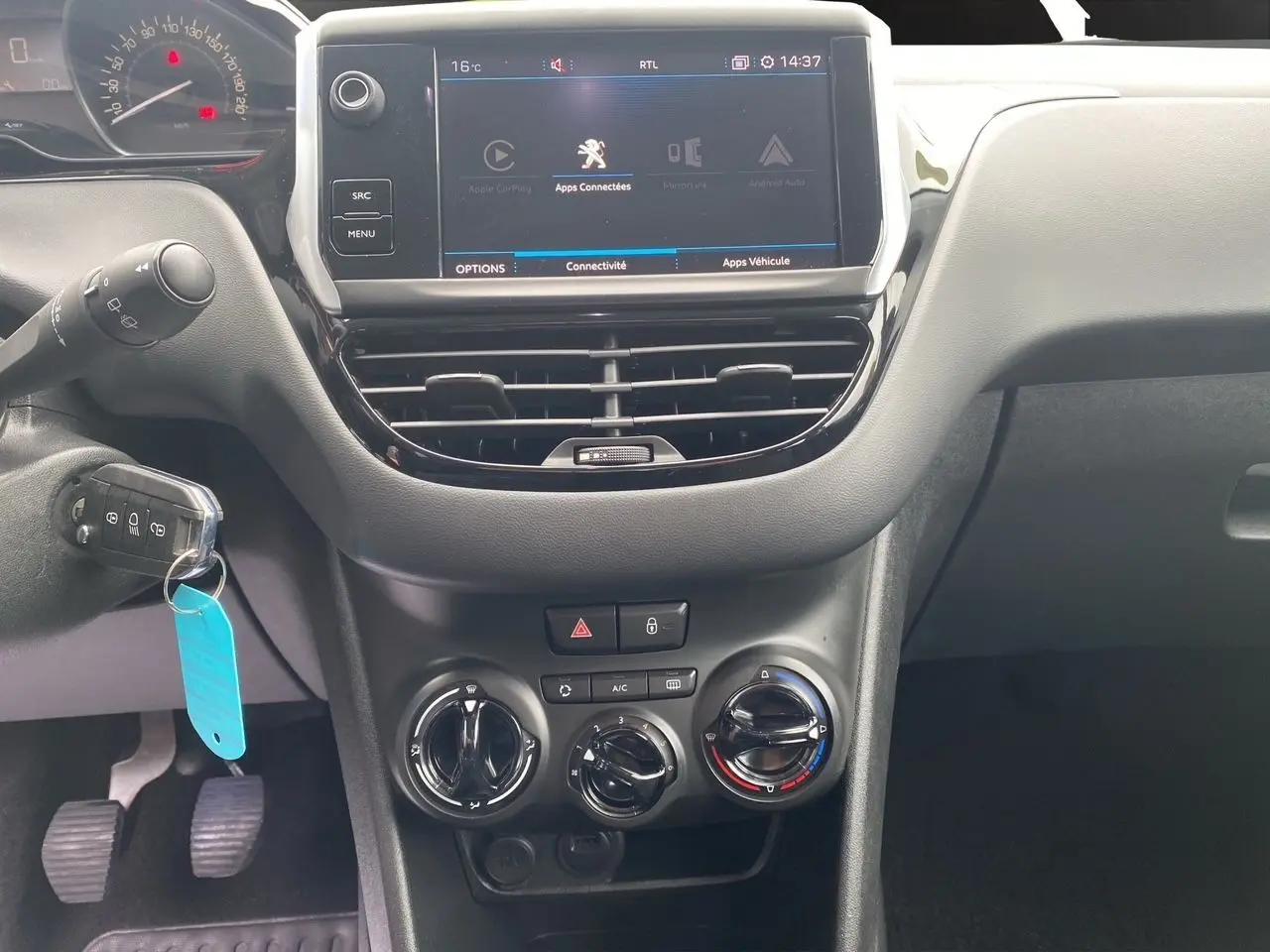 Intérieur noir du tableau de bord Peugeot 208 Affaire 2019, vue centrée sur l'écran tactile et commandes climatisation.